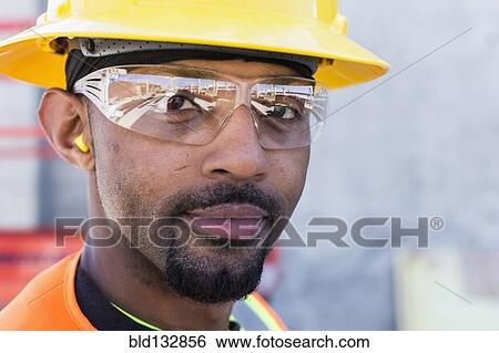 Stock Photograph - Black worker smiling on construction site. Fotosearch
