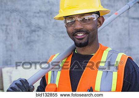 Stock Photography - Black worker smiling on construction site. Fotosearch
