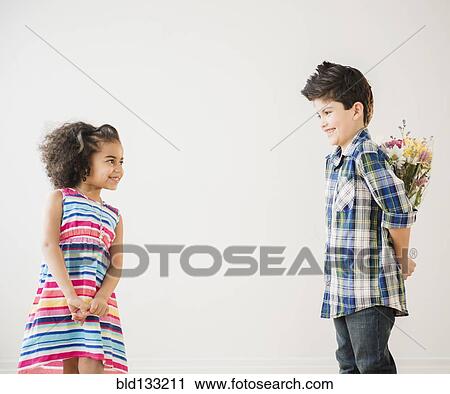 Stock Image - Boy giving girl bouquet of flowers. Fotosearch