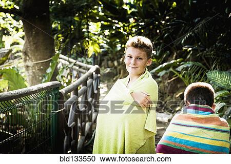 Stock Image - Boys wrapped in towels in jungle. Fotosearch