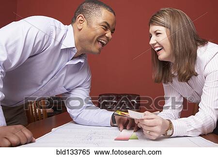 Stock Photography - Business people laughing in conference room. Fotosearch