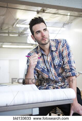 Caucasian architect designing blueprints in office View Large Photo Image Stock Image - Caucasian architect designing blueprints in office. Fotosearch