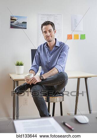 Picture - Caucasian architect drinking coffee in office. Fotosearch