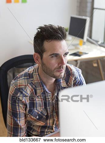 Stock Photo - Caucasian architect working in office. Fotosearch