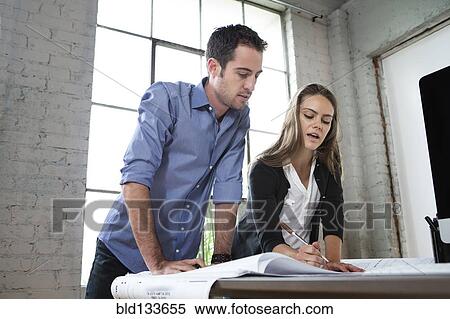 Caucasian architects designing blueprints in office View Large Photo Image Stock Photography - Caucasian architects designing blueprints in office. Fotosearch