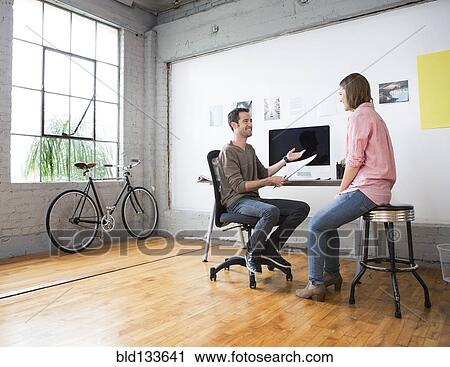 Stock Image - Caucasian architects talking in office. Fotosearch