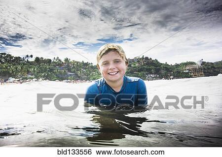 Stock Photograph - Caucasian boy swimming in ocean. Fotosearch