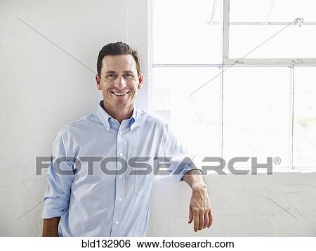 Stock Photograph - Caucasian businessman smiling in office. Fotosearch