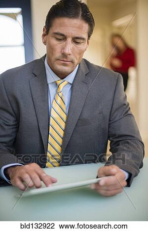 Stock Image - Caucasian businessman using digital tablet. Fotosearch