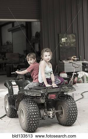 Caucasian children playing on four wheeler View Large Photo Image Stock Image - Caucasian children playing on four wheeler . Fotosearch