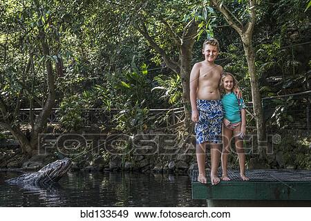 Caucasian children smiling by rural lake View Large Photo Image Stock Photo - Caucasian children smiling by rural lake. Fotosearch