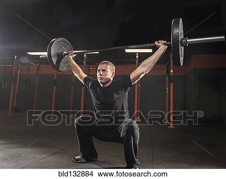 Caucasian man lifting weights in gym View Large Photo Image Picture - Caucasian man lifting weights in gym. Fotosearch