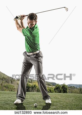 Stock Image - Caucasian man playing golf on course. Fotosearch