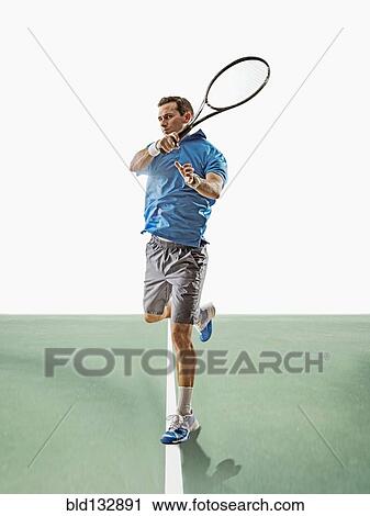 Caucasian man playing tennis on court View Large Photo Image Stock Image - Caucasian man playing tennis on court. Fotosearch