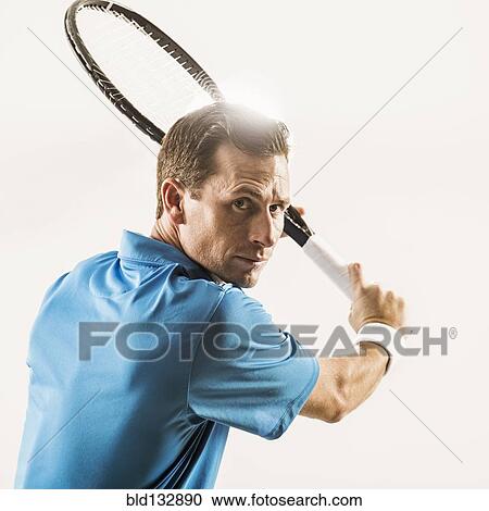 Stock Image - Caucasian man playing tennis. Fotosearch