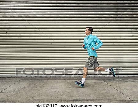 Caucasian man running on city street View Large Photo Image Stock Photo - Caucasian man running on city street. Fotosearch