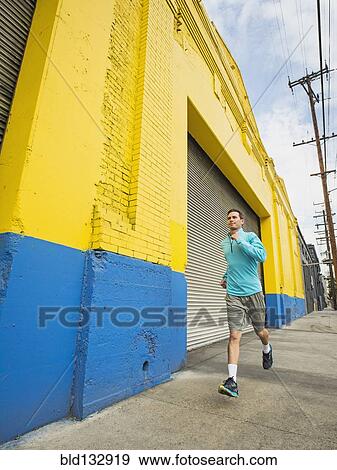 Caucasian man running on city street View Large Photo Image Stock Photo - Caucasian man running on city street. Fotosearch