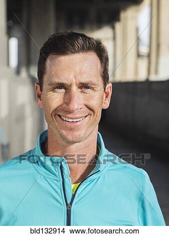 Picture - Caucasian man smiling in urban tunnel. Fotosearch
