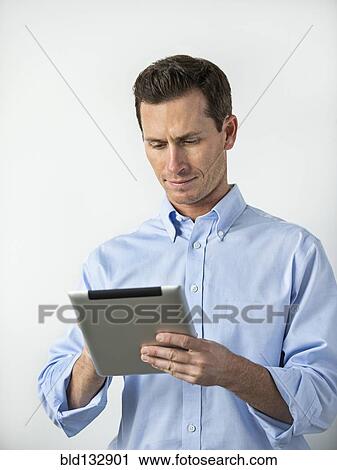 Caucasian man using digital tablet View Large Photo Image Stock Image - Caucasian man using digital tablet. Fotosearch