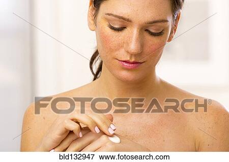 Stock Photo - Caucasian woman applying lotion. Fotosearch