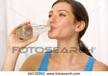 Stock Image - Caucasian woman drinking water. Fotosearch