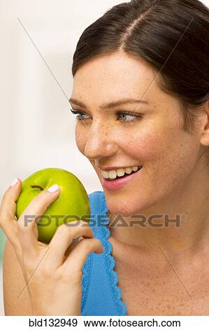 Stock Photo - Caucasian woman eating apple. Fotosearch