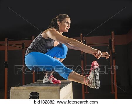 Stock Image - Caucasian woman exercising in gym. Fotosearch