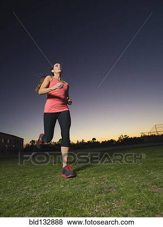 Stock Photo - Caucasian woman jogging outdoors at sunrise. Fotosearch