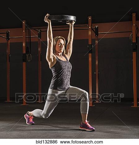 Caucasian woman lifting weights in gym View Large Photo Image Stock Photograph - Caucasian woman lifting weights in gym. Fotosearch