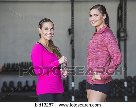 Stock Image - Caucasian women smiling in gym. Fotosearch