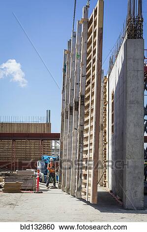 Stock Image - Caucasian worker by wall form at construction site. Fotosearch