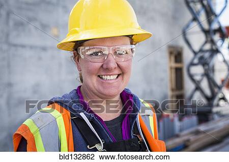 Stock Image - Caucasian worker wearing safety goggles on site. Fotosearch