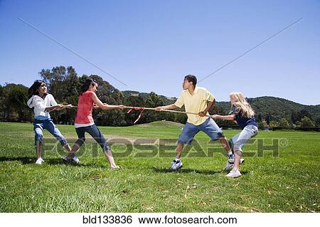Stock Photograph - Children playing tug-of-war in field. Fotosearch