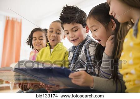Picture - Children reading together in living room. Fotosearch