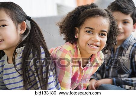 Stock Image - Children smiling in living room. Fotosearch
