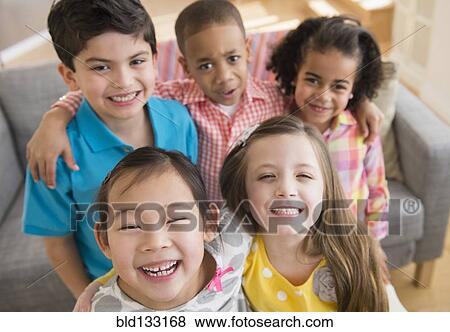 Stock Photo - Children smiling together in living room. Fotosearch