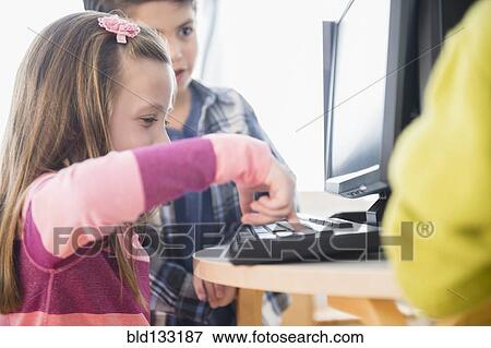 Stock Photo - Children using computers in classroom. Fotosearch
