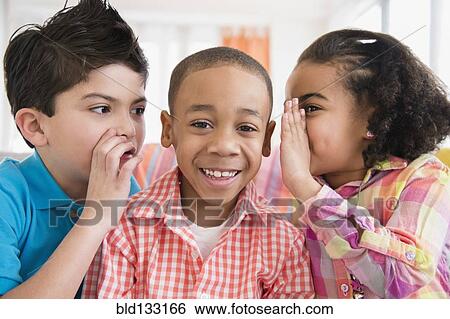 Stock Photograph - Children whispering into friend's ears. Fotosearch