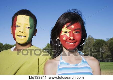 Stock Image - Children with Guinean and Chinese flags painted on faces. Fotosearch