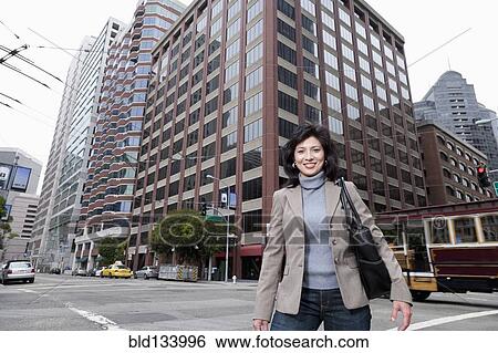 Chinese businesswoman standing on city street View Large Photo Image Stock Photograph - Chinese businesswoman standing on city street. Fotosearch