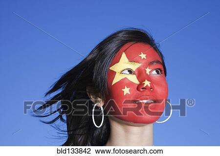 Stock Image - Chinese girl with Chinese flag painted on face. Fotosearch