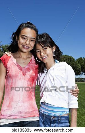 Stock Photography - Chinese girls hugging outdoors. Fotosearch