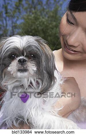 Picture - Chinese woman holding dog. Fotosearch