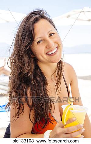 Stock Photo - Chinese woman relaxing on beach. Fotosearch