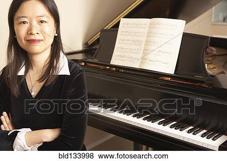Chinese woman sitting at piano View Large Photo Image Stock Photo - Chinese woman sitting at piano. Fotosearch