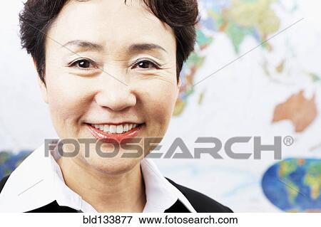 Stock Photo - Chinese woman smiling by world map. Fotosearch