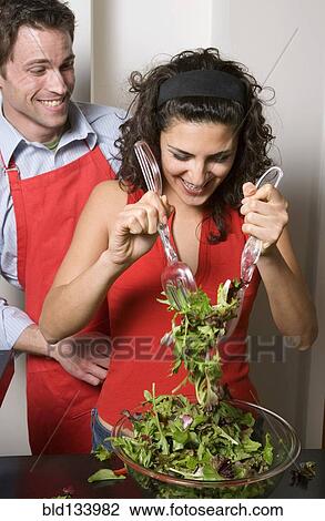 Couple cooking together in kitchen View Large Photo Image Stock Image - Couple cooking together in kitchen. Fotosearch