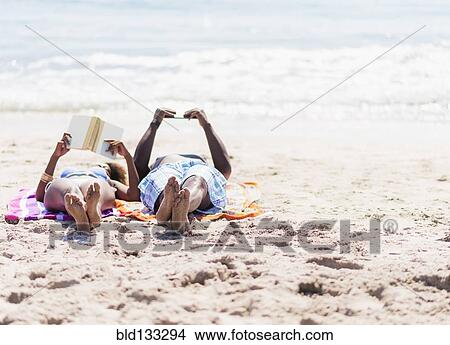 Couple relaxing together on beach View Large Photo Image Picture - Couple relaxing together on beach. Fotosearch