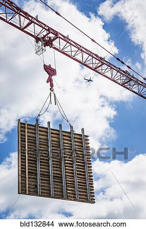 Picture - Crane lifting concrete wall form on construction site. Fotosearch
