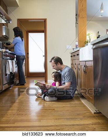 Father reading to daughter in kitchen View Large Photo Image Stock Image - Father reading to daughter in kitchen. Fotosearch
